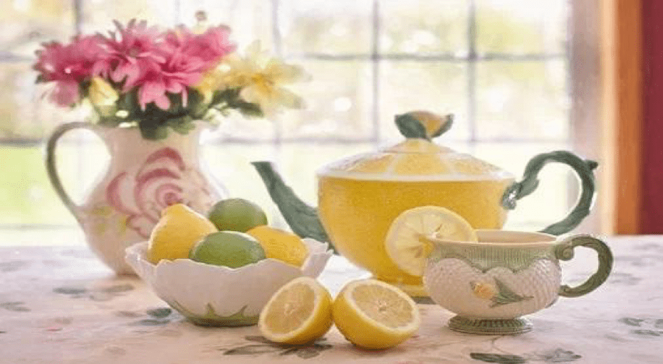 teacup set, vase with flowers, and bowl of lemons and limes