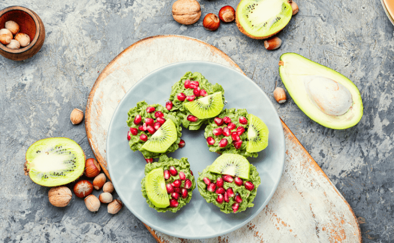 avocados with kiwi and pomegranate seeds on plate by dr michele ross