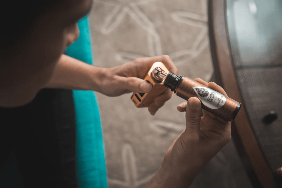 man filling up his vaporizer with cannabis oil