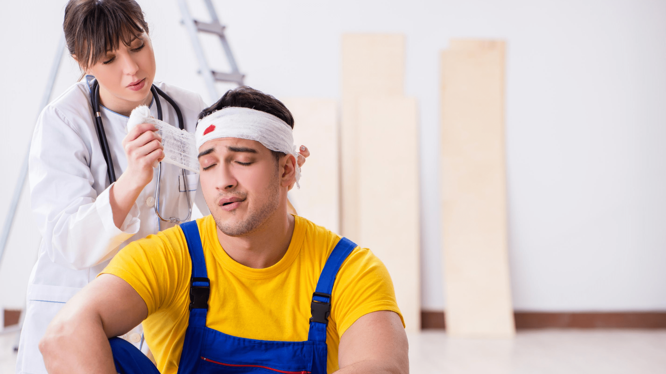man gets bleeding head bandaged by young asian doctor on construction site