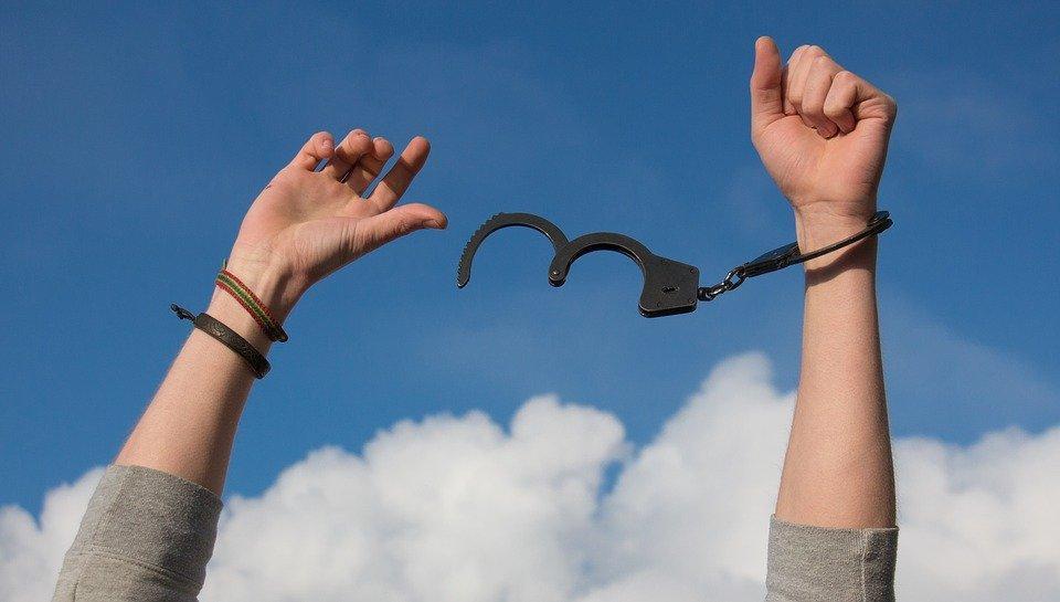 woman breaking free from handcuffs as metaphor for addiction recovery