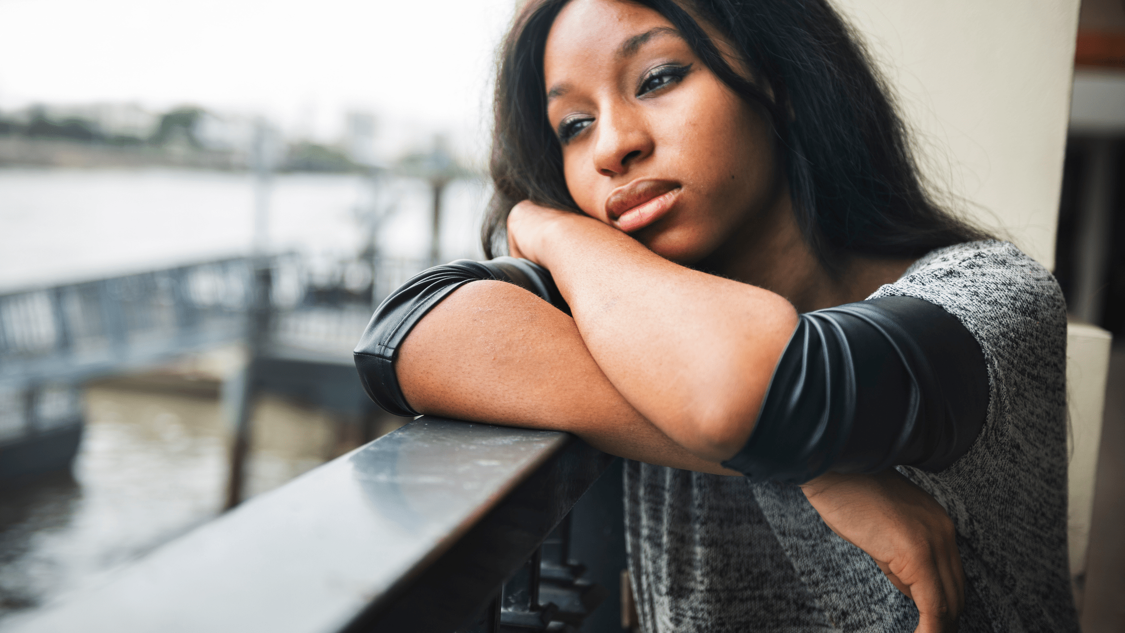 young black women is depressed and sitting outside on balcony