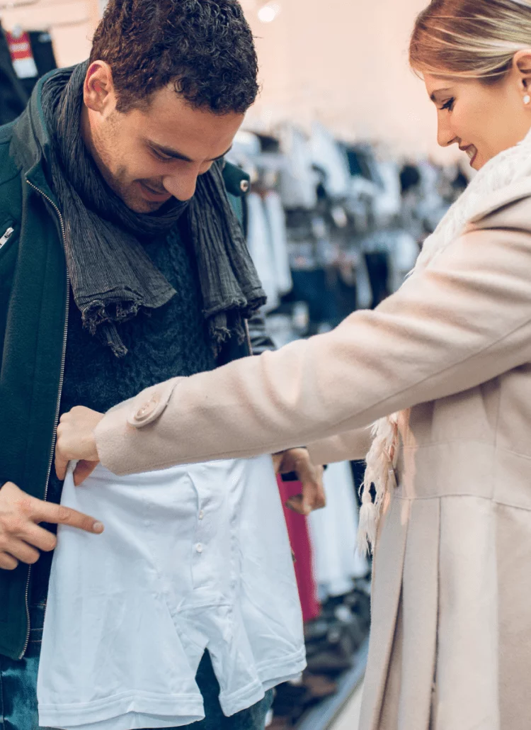 man trying on underwear in store with his wife