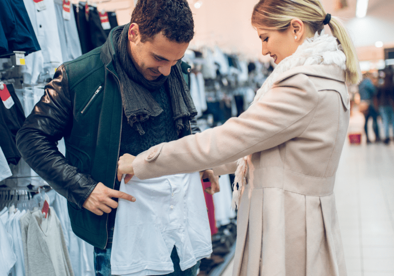 man trying on underwear in store with his wife