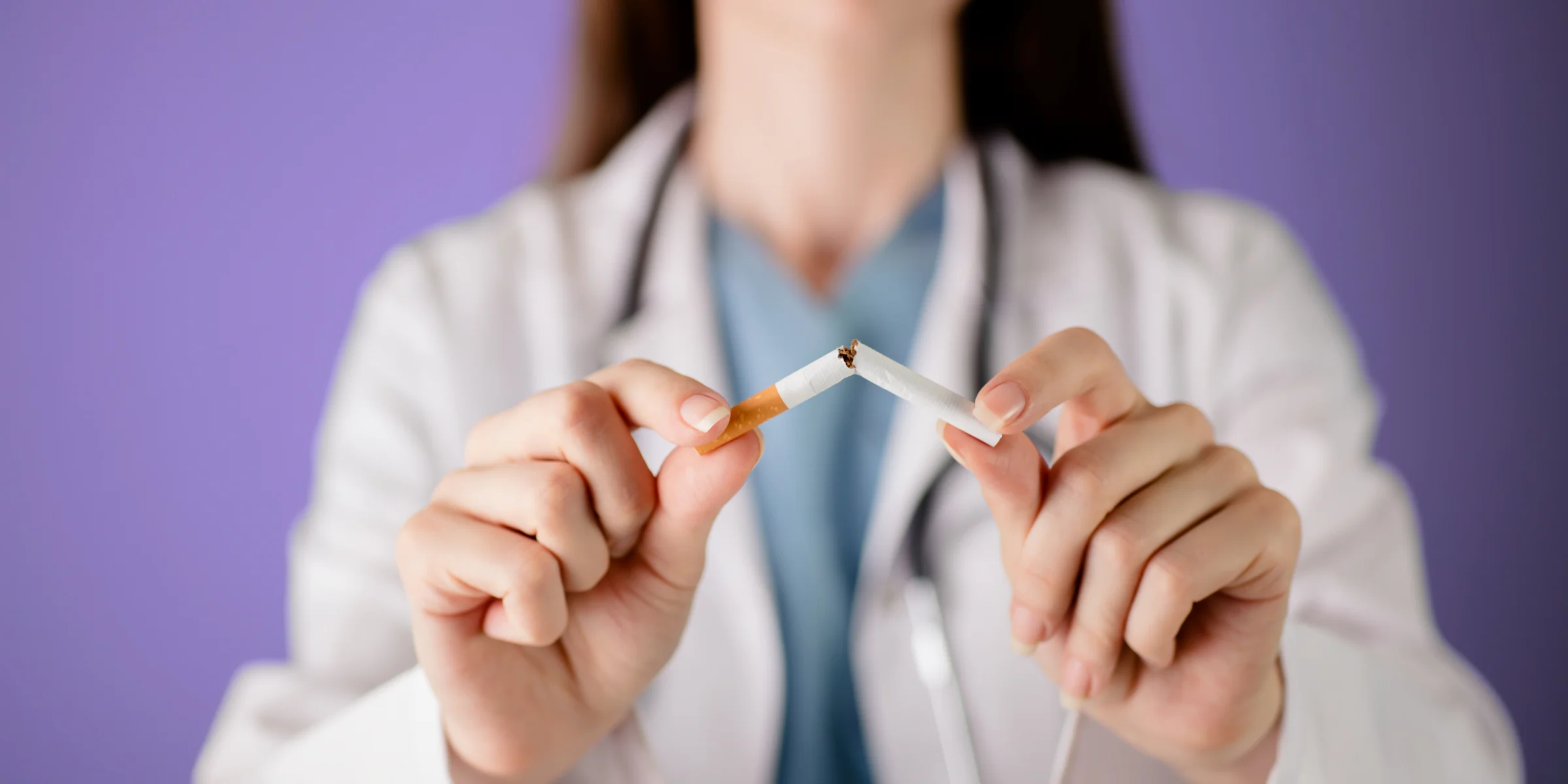 doctor breaking cigarette to help female patients quit smoking