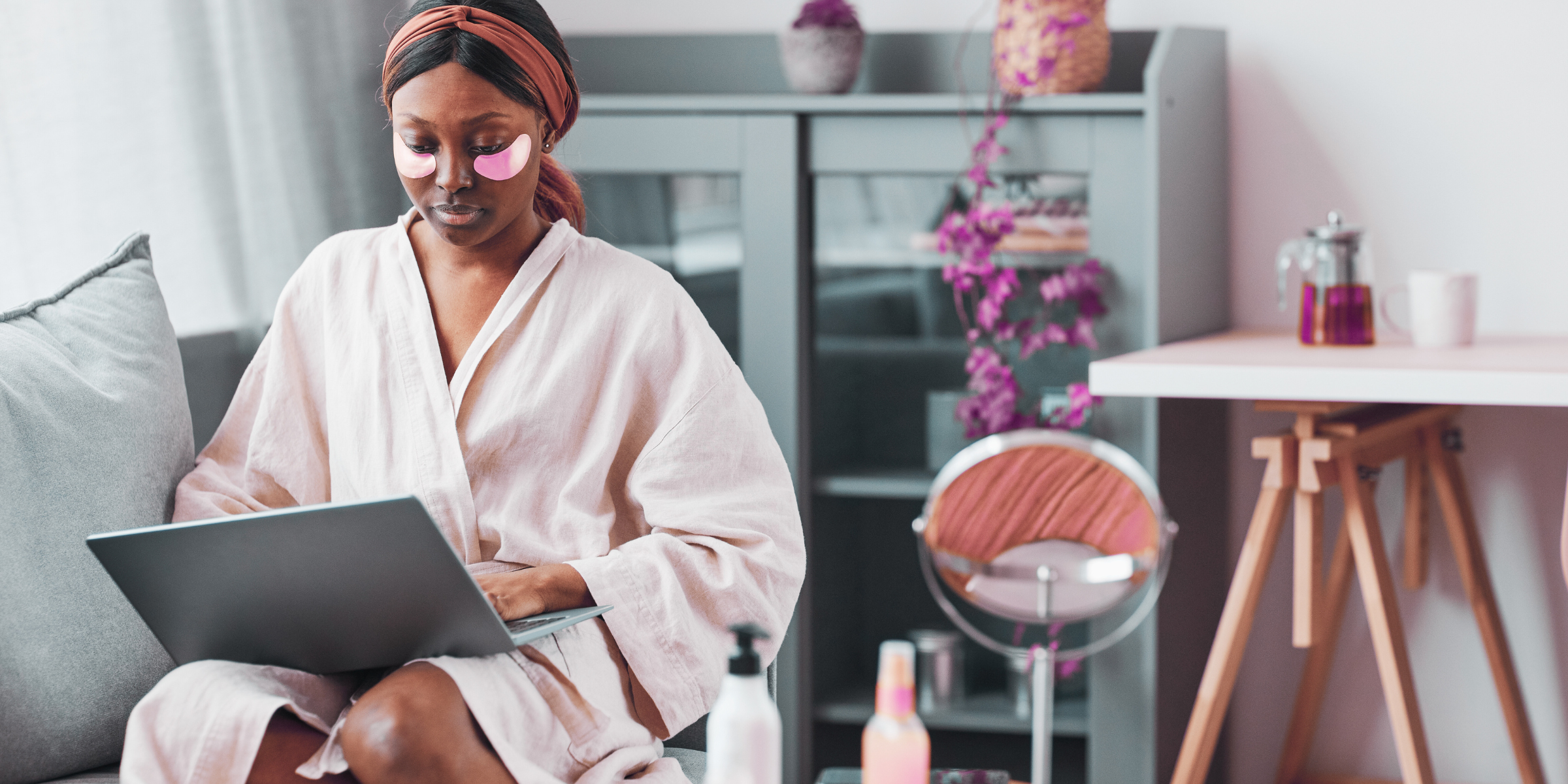 young black woman in spa robe typing on laptop doing self-care for healthier lifestyle