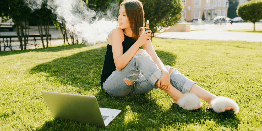 young woman in college quad vaping cannabis