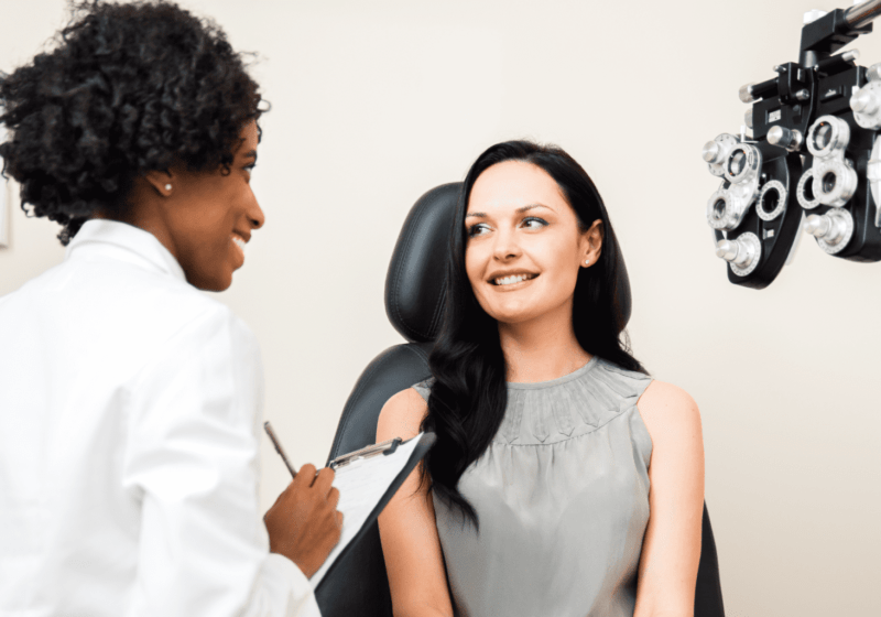 black eye doctor talk to female patient about vision in medical checkup