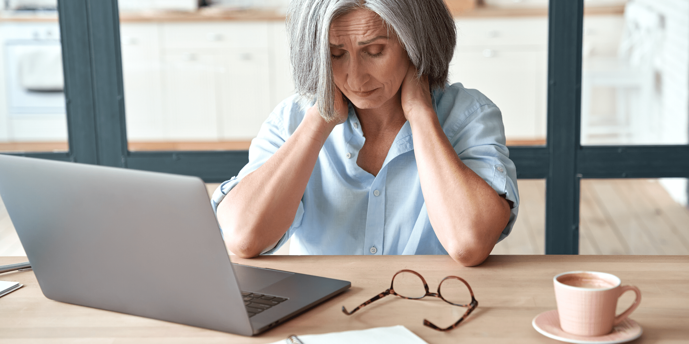 senior woman hurting neck at office desk