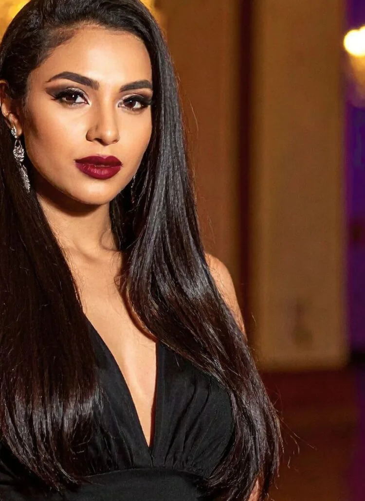brunette woman in black evening gown looking confident