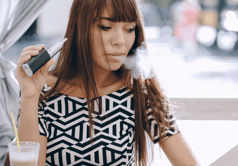 young woman vaping cbd cannabis