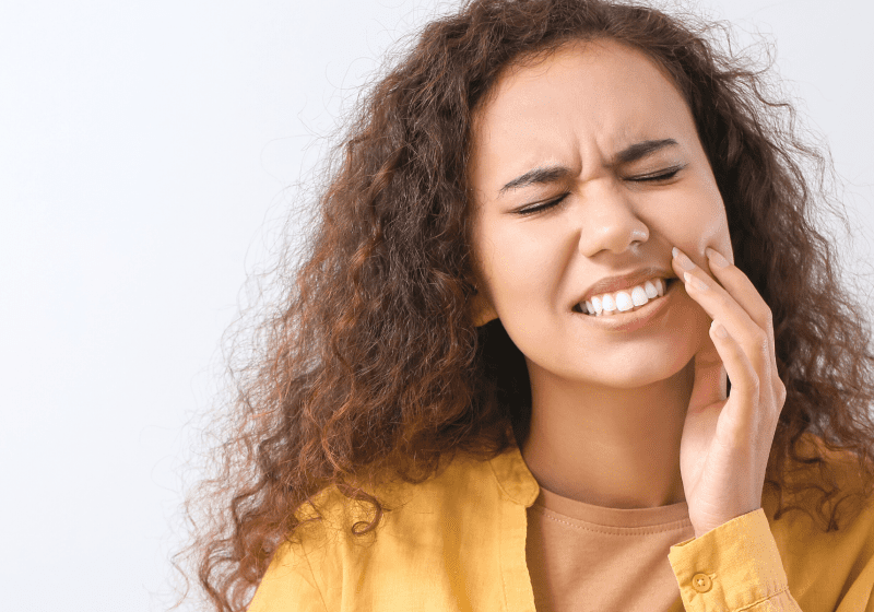 curly haired woman with tooth pain