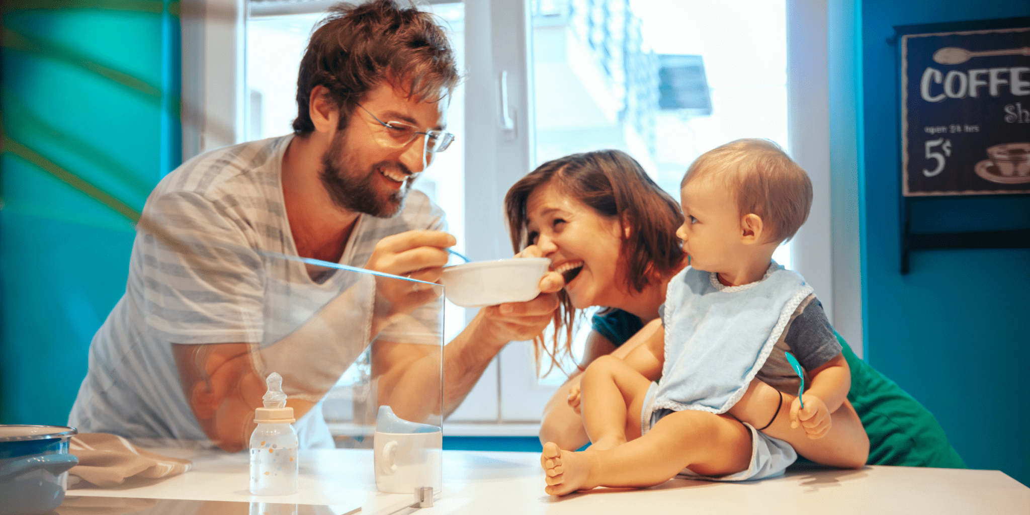 Happy new parents feeding their baby in a cafe