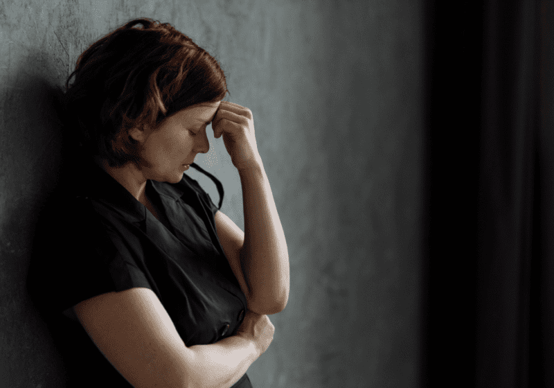 redheaded woman looks depressed over long-covid symptoms