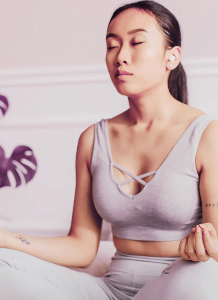 young asian woman in bedroom meditating for stress and more youthful appearance