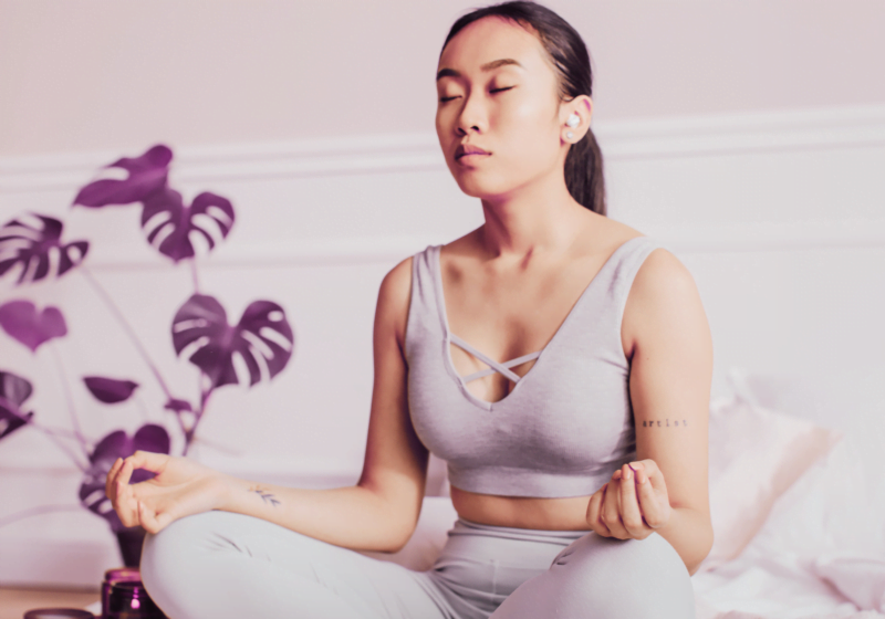 young asian woman in bedroom meditating for stress and more youthful appearance