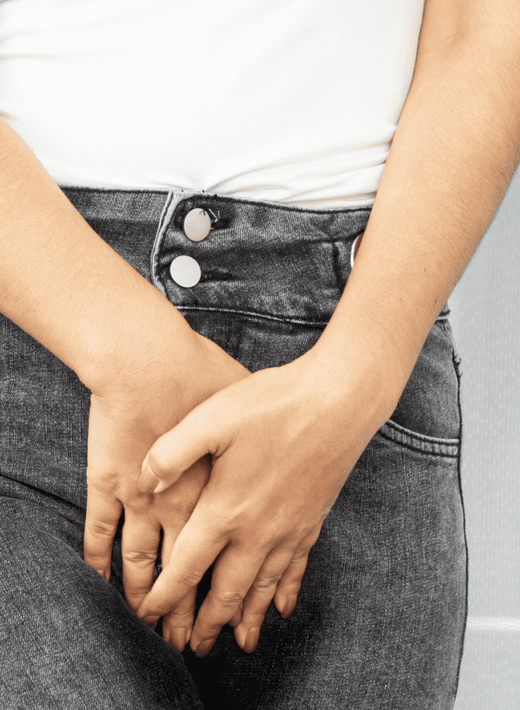young woman in jeans holding bladder frequent urination