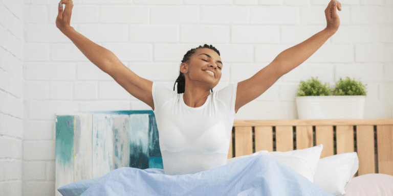 young black woman in white shirt waking up in the morning out of bed