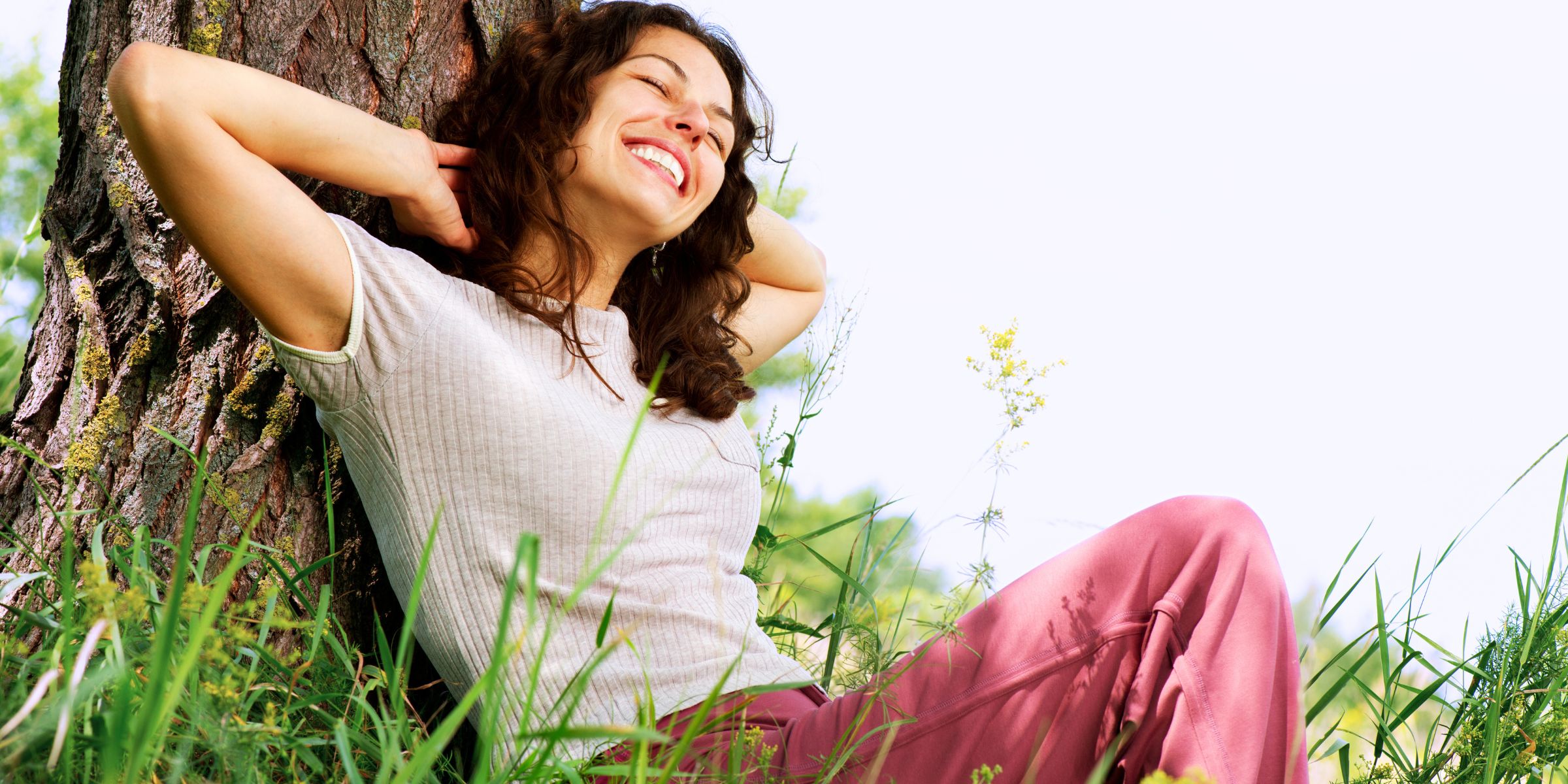 woman relaxing outside on tree stress-free