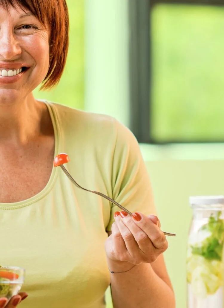 woman eating a salad for a healthy diet as she ages