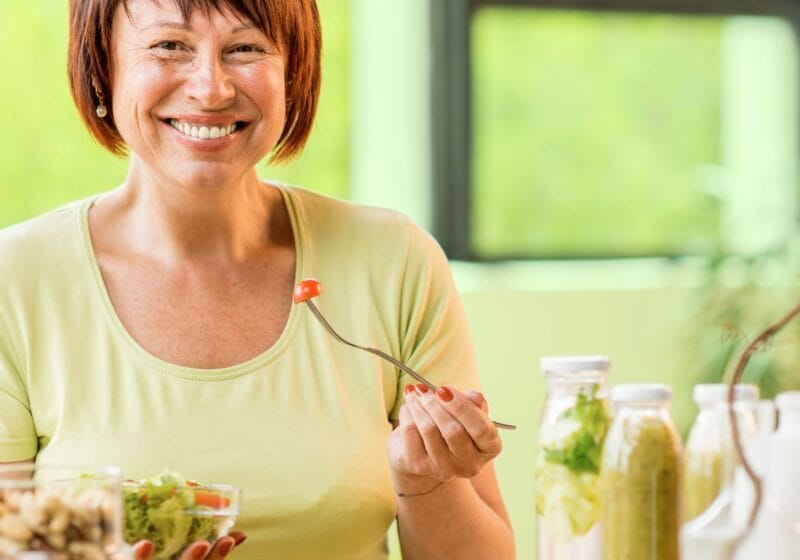 woman eating a salad for a healthy diet as she ages