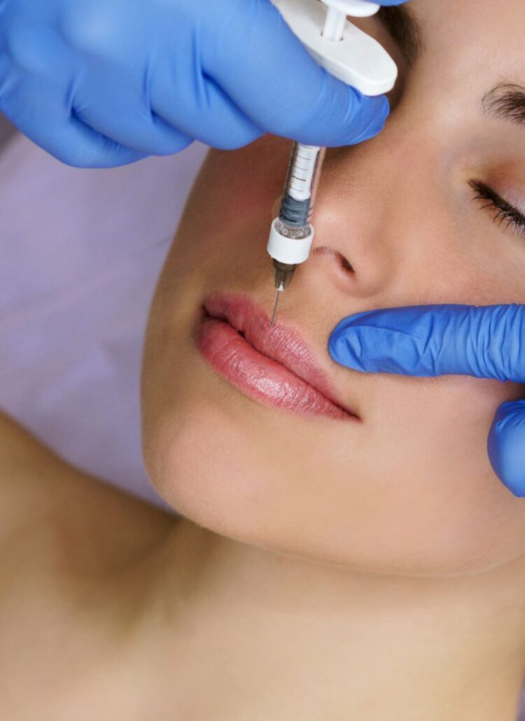 woman receiving lip filler injection cosmetic surgery to look better