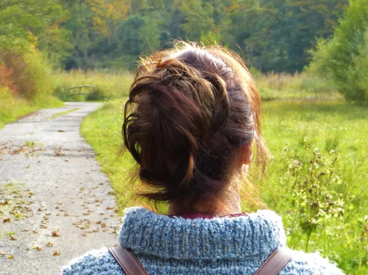 woman in blue sweater relaxing by walking outside