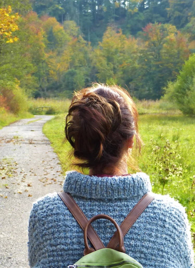 woman in blue sweater relaxing by walking outside