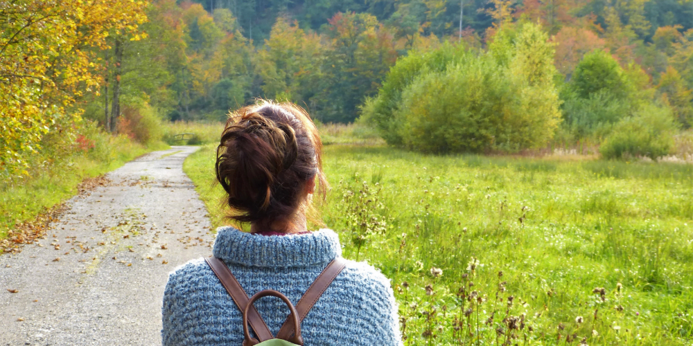 young woman taking a walk outside in the forest to decrease stress