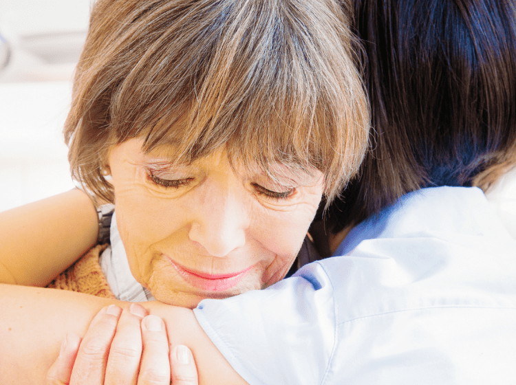 grandma grieving over death of husband hugging family