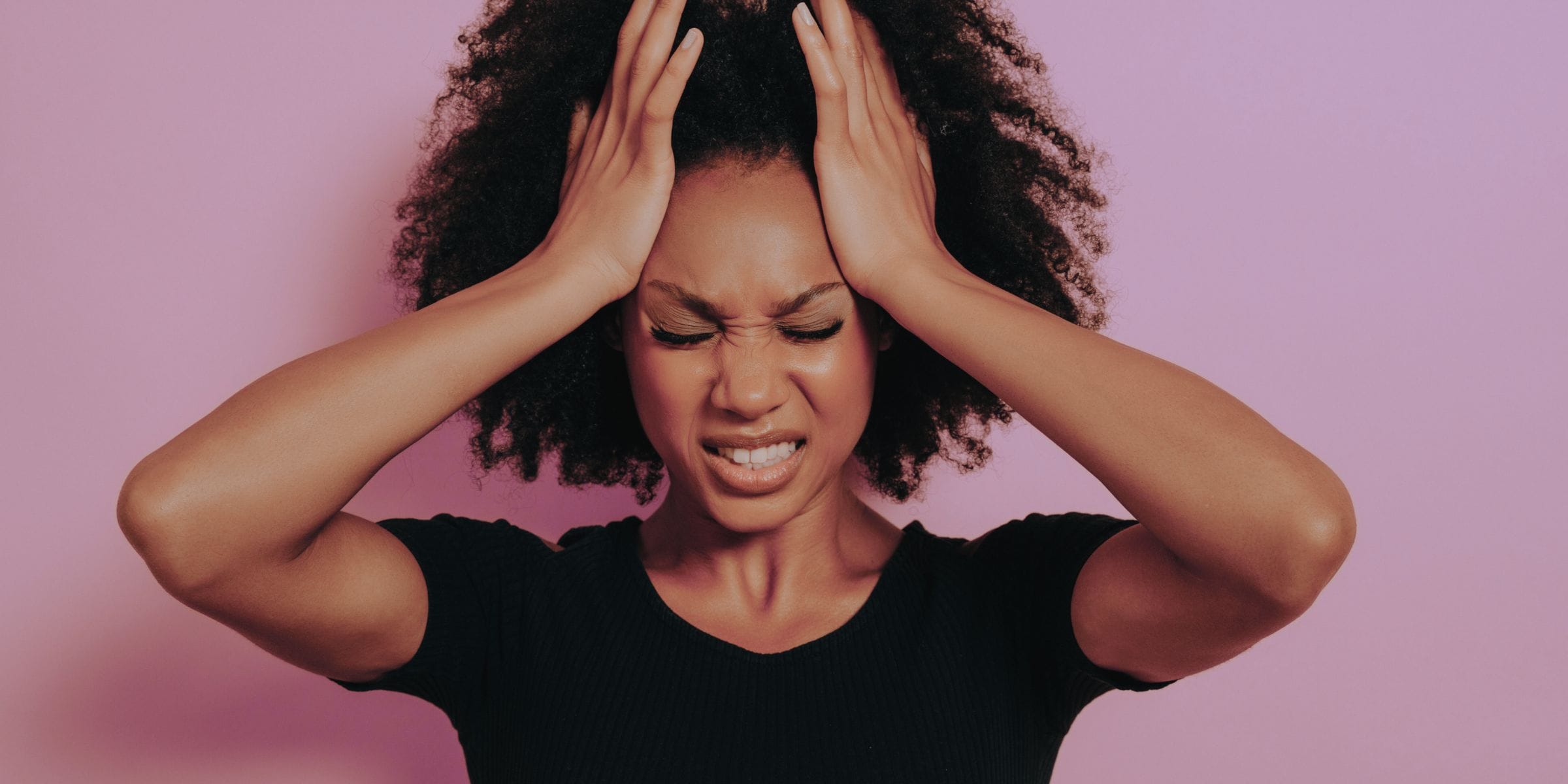 Young black woman holding head stressed