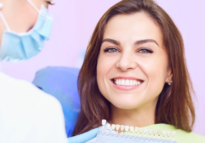 woman in dentist office smiling about to get dental implants