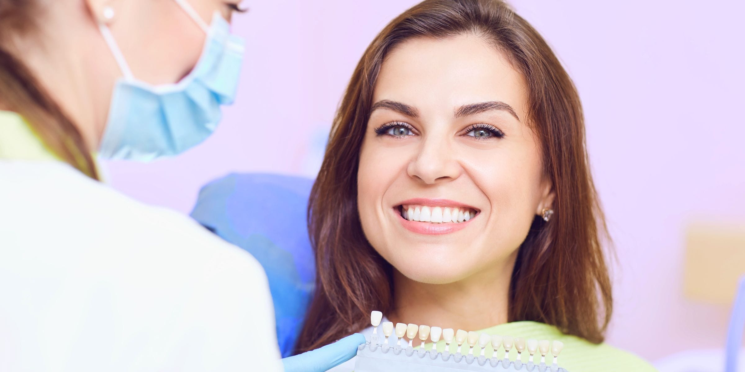 woman in dentist office smiling about to get dental implants