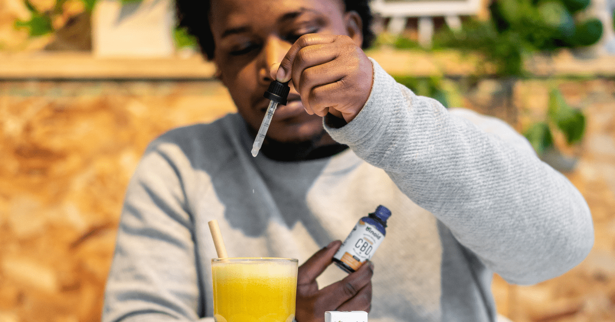 UK man dropping cbd oil extract into orange juice