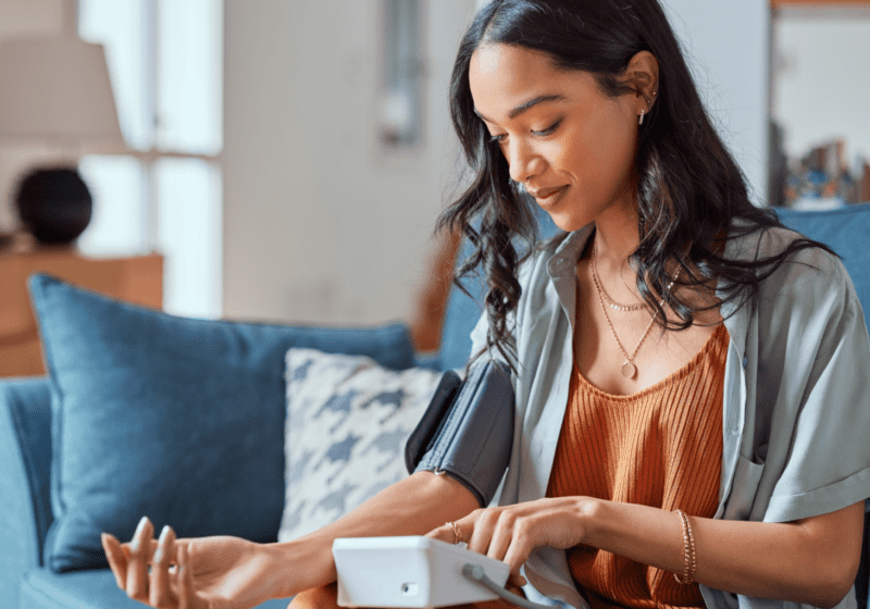 young woman checking blood pressure treating hypertension with CBD oil