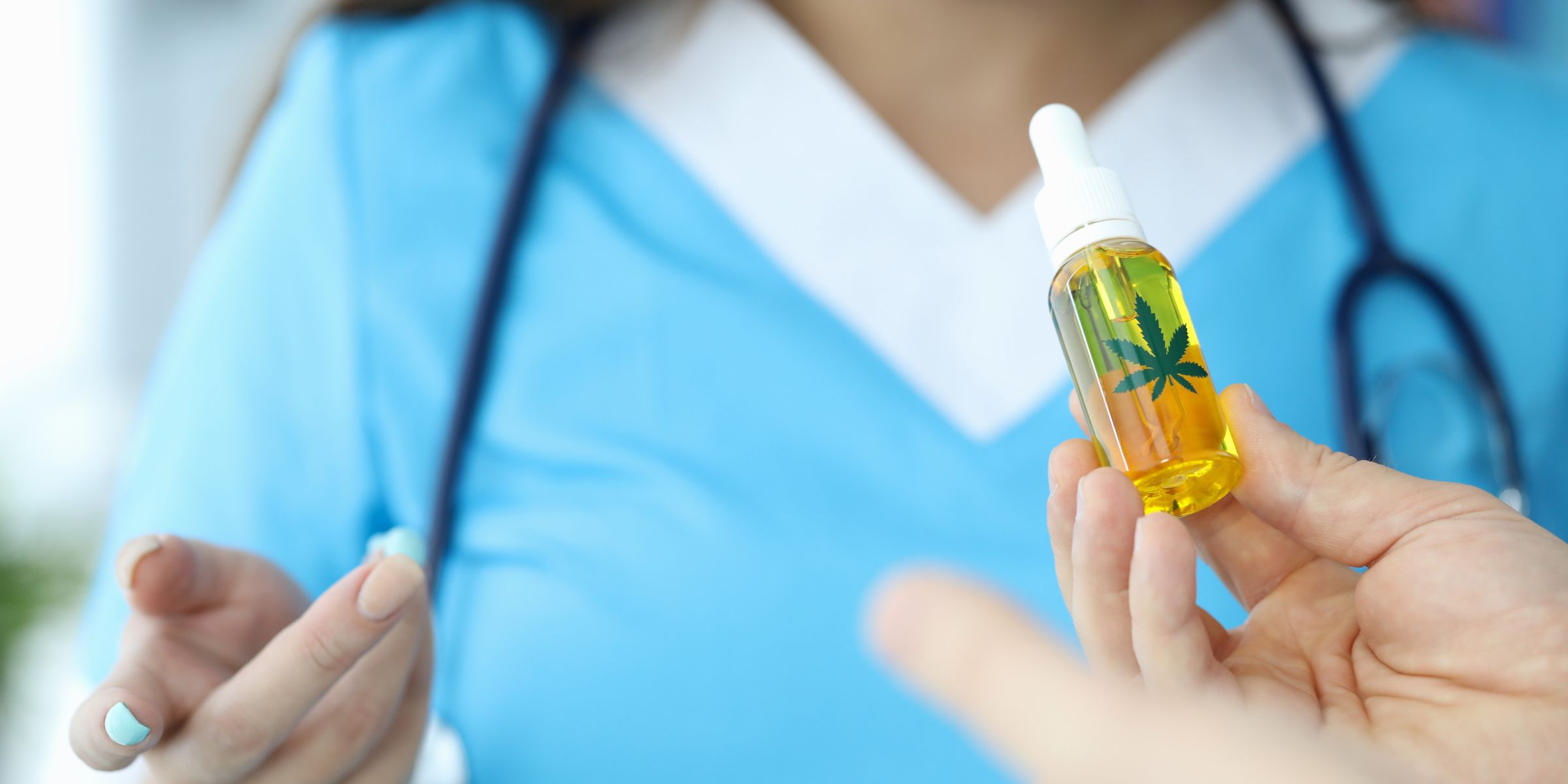 woman holding CBD oil bottle with pot leaf on it from cannabis nurse