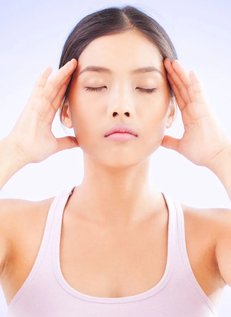 young asian woman with her eyes closed clearing her mind meditating