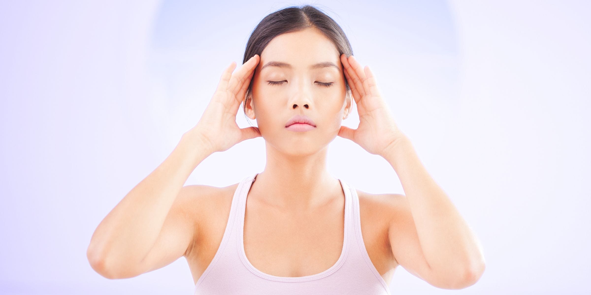 young asian woman with her eyes closed clearing her mind meditating