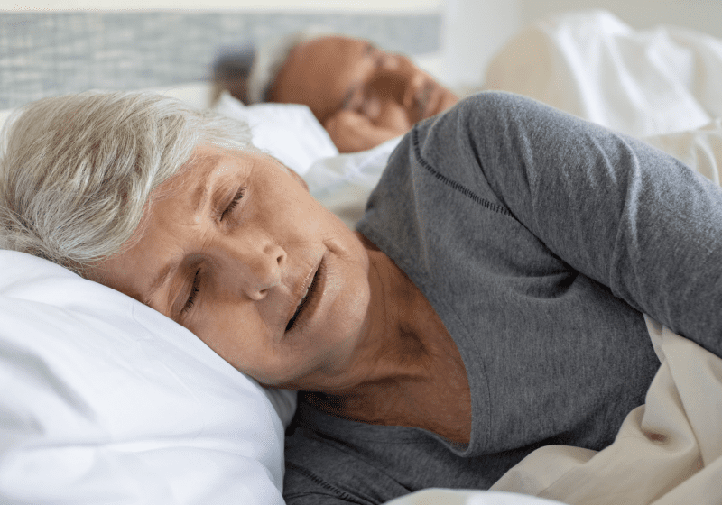 senior woman sleeping in bed with restless leg syndrome