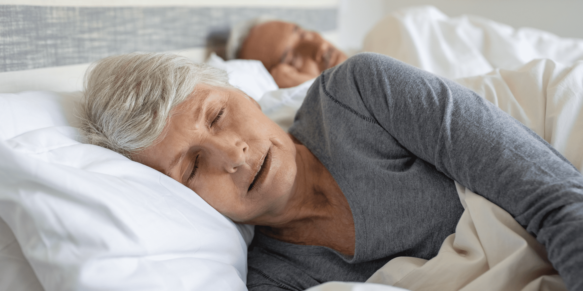 senior woman sleeping in bed with restless leg syndrome