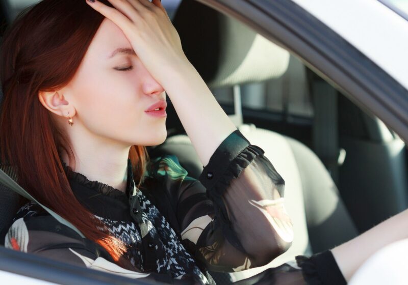 redhead woman hitting forehead in frustration road rage in car stressed out