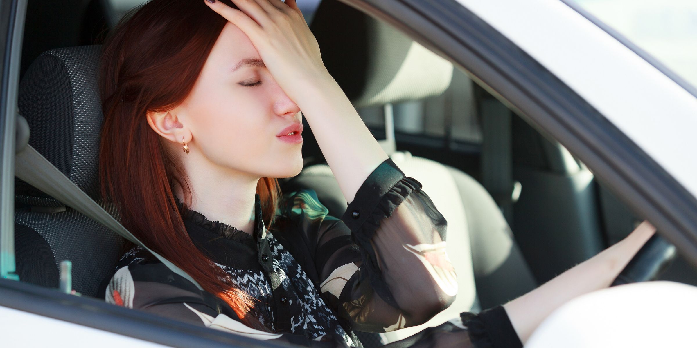redhead woman hitting forehead in frustration road rage in car stressed out