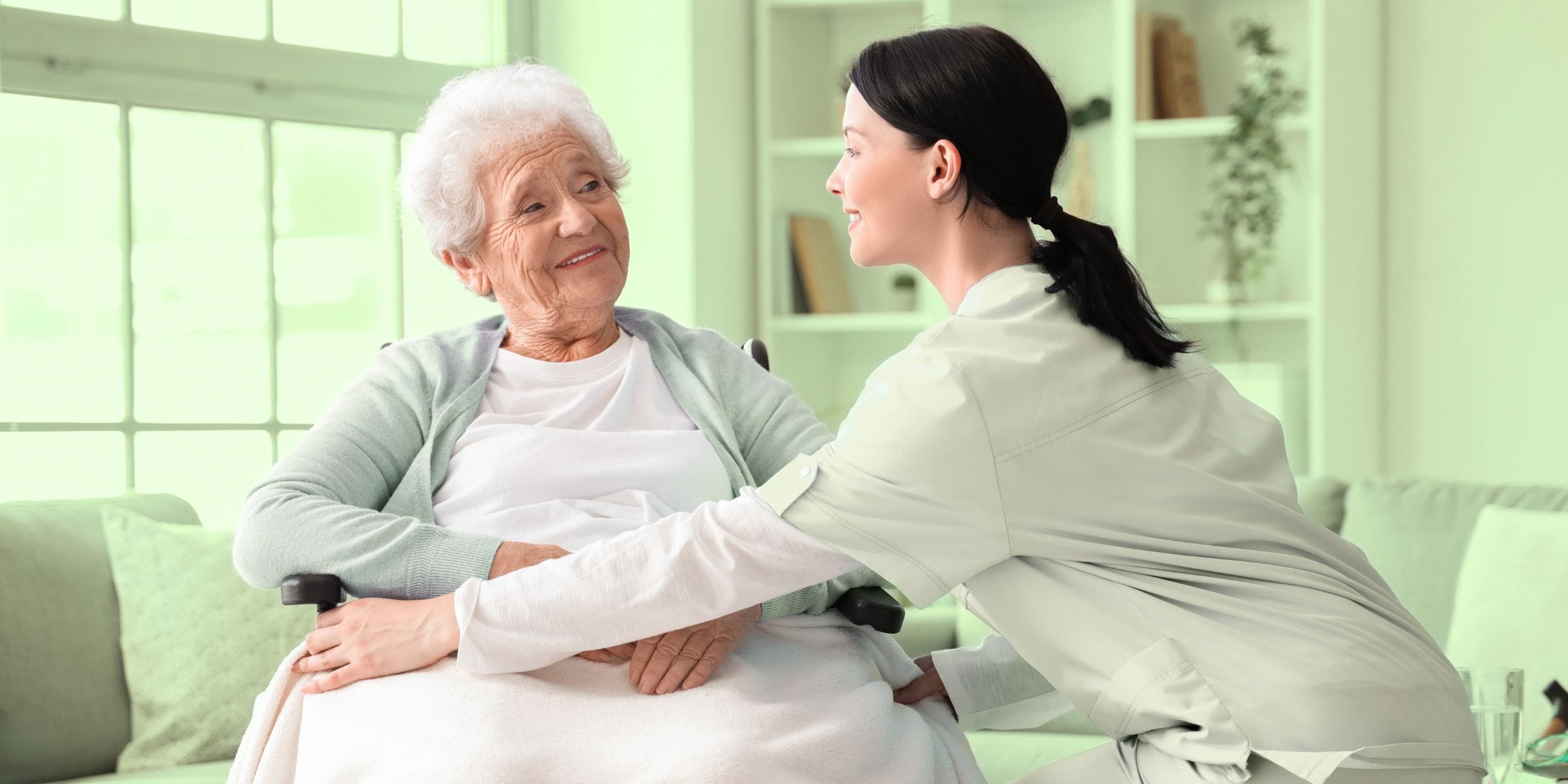 senior woman in a wheelchair being taken care of nurse in palliative care hospice