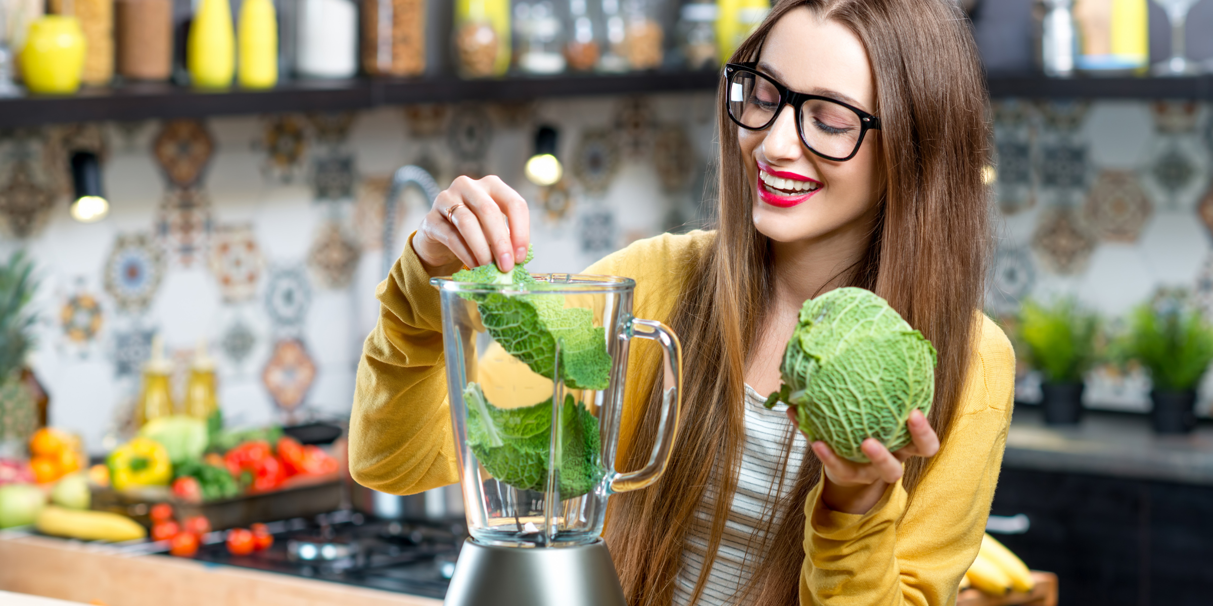 woman juicing lettuce in blender in the kitchen for a healthy detox