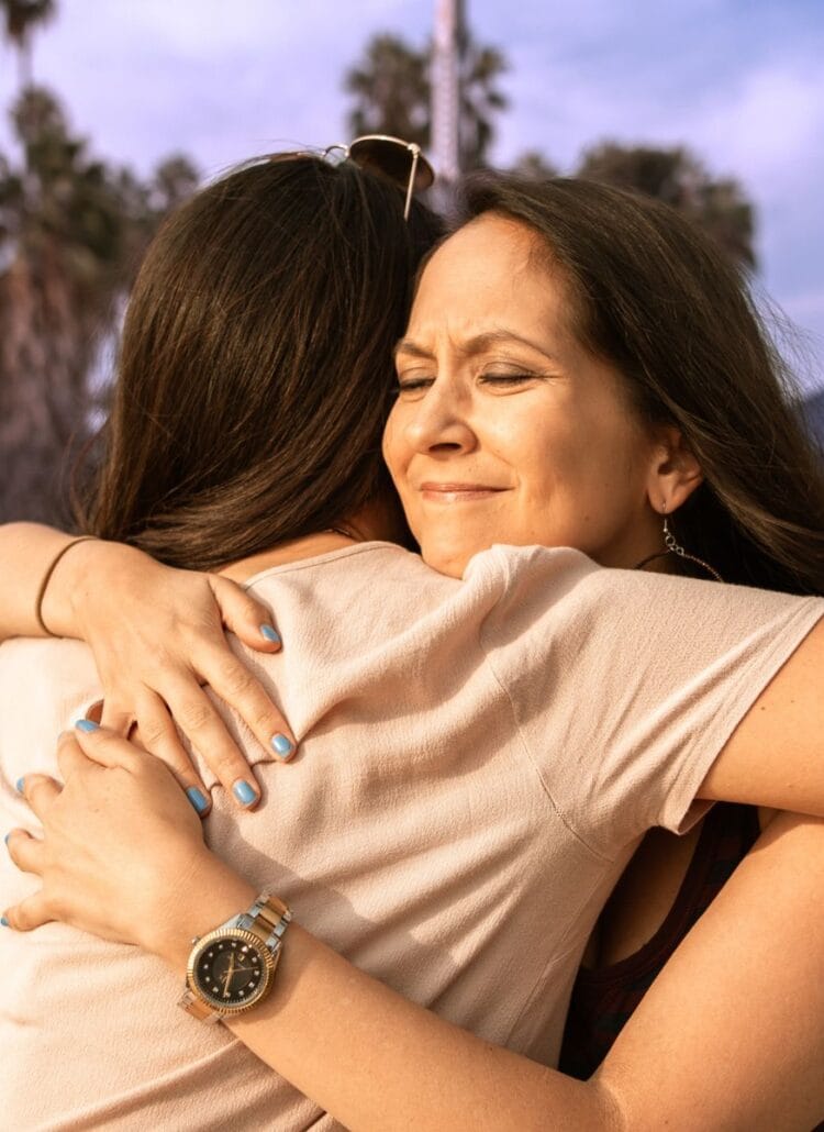 woman hugging friend with chronic health issues outside in park