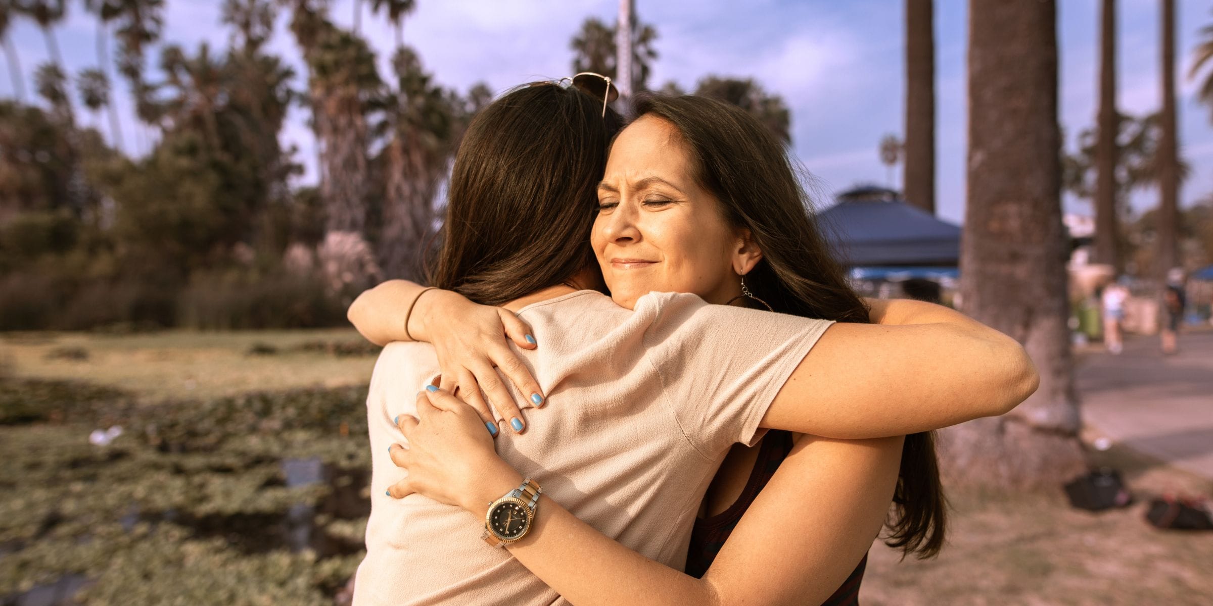 woman hugging friend with chronic health issues outside in park