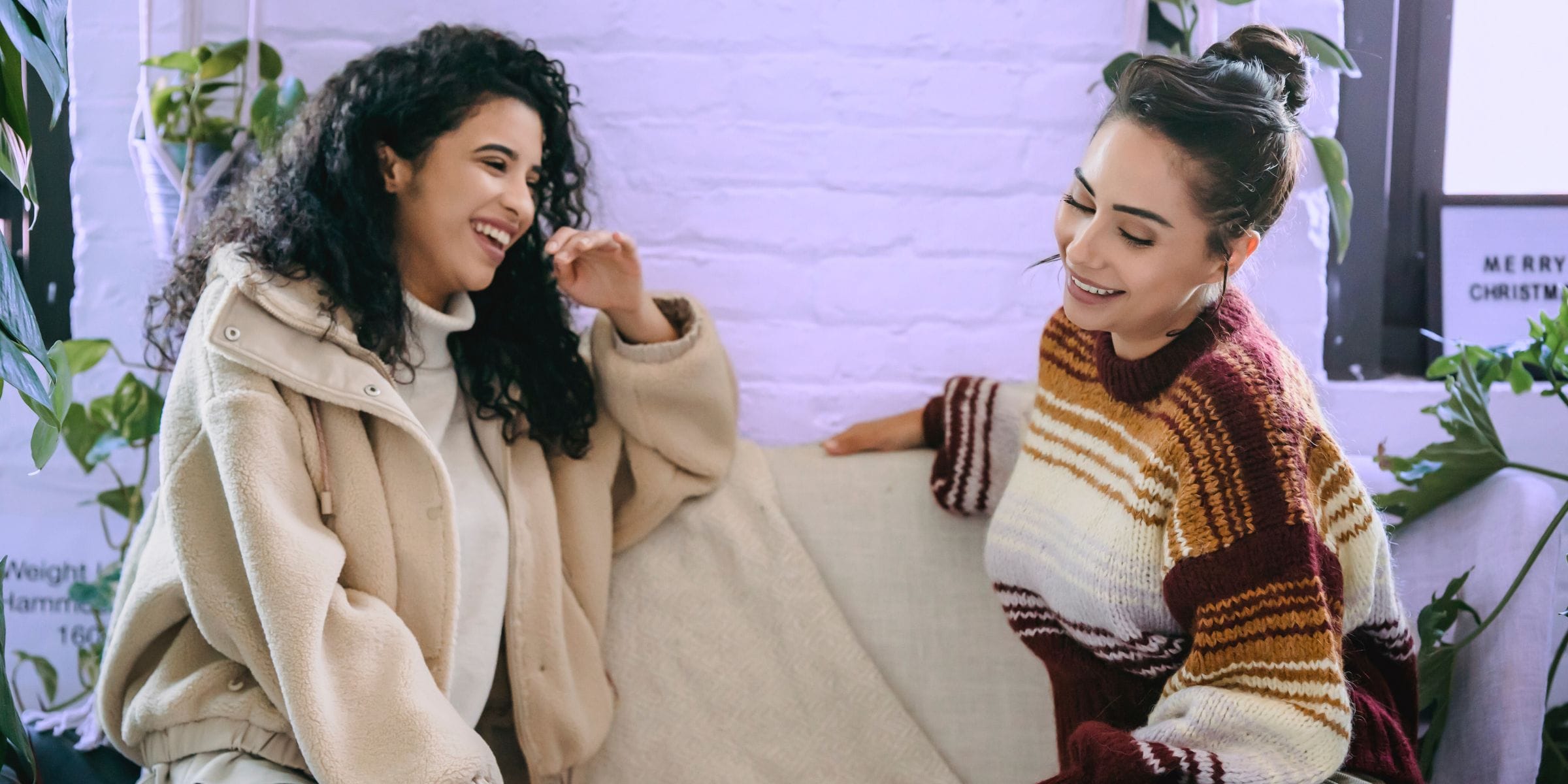 happy female friends talking on the couch creating a meaningful relationship