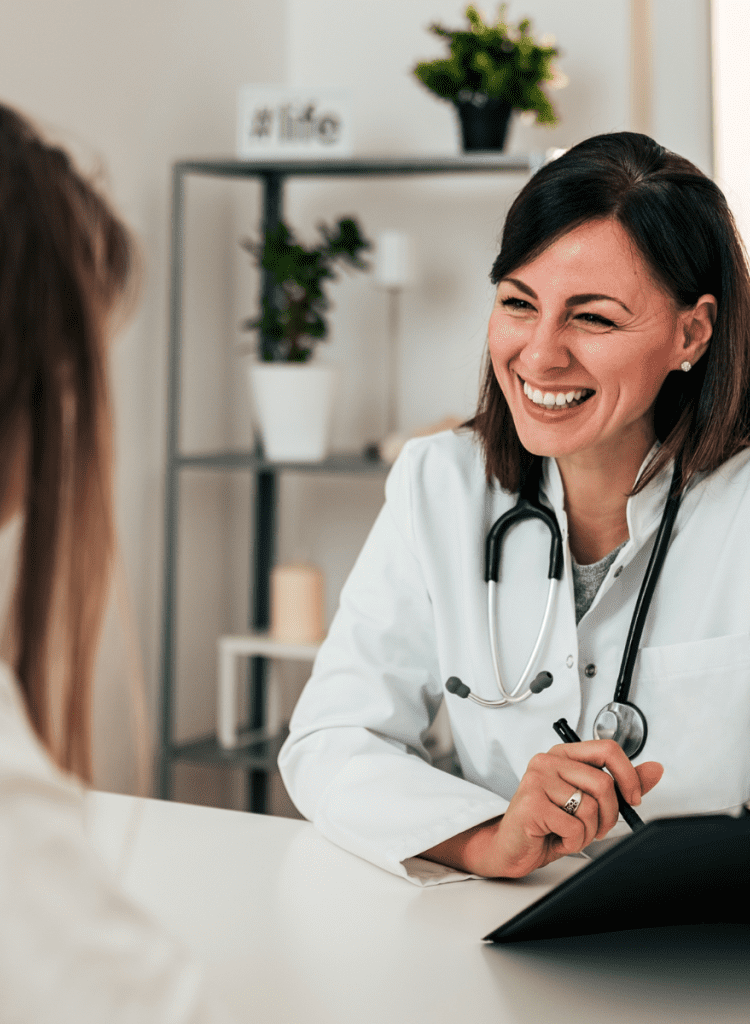 woman doctor smiling talking to satisfied female patient with long hair