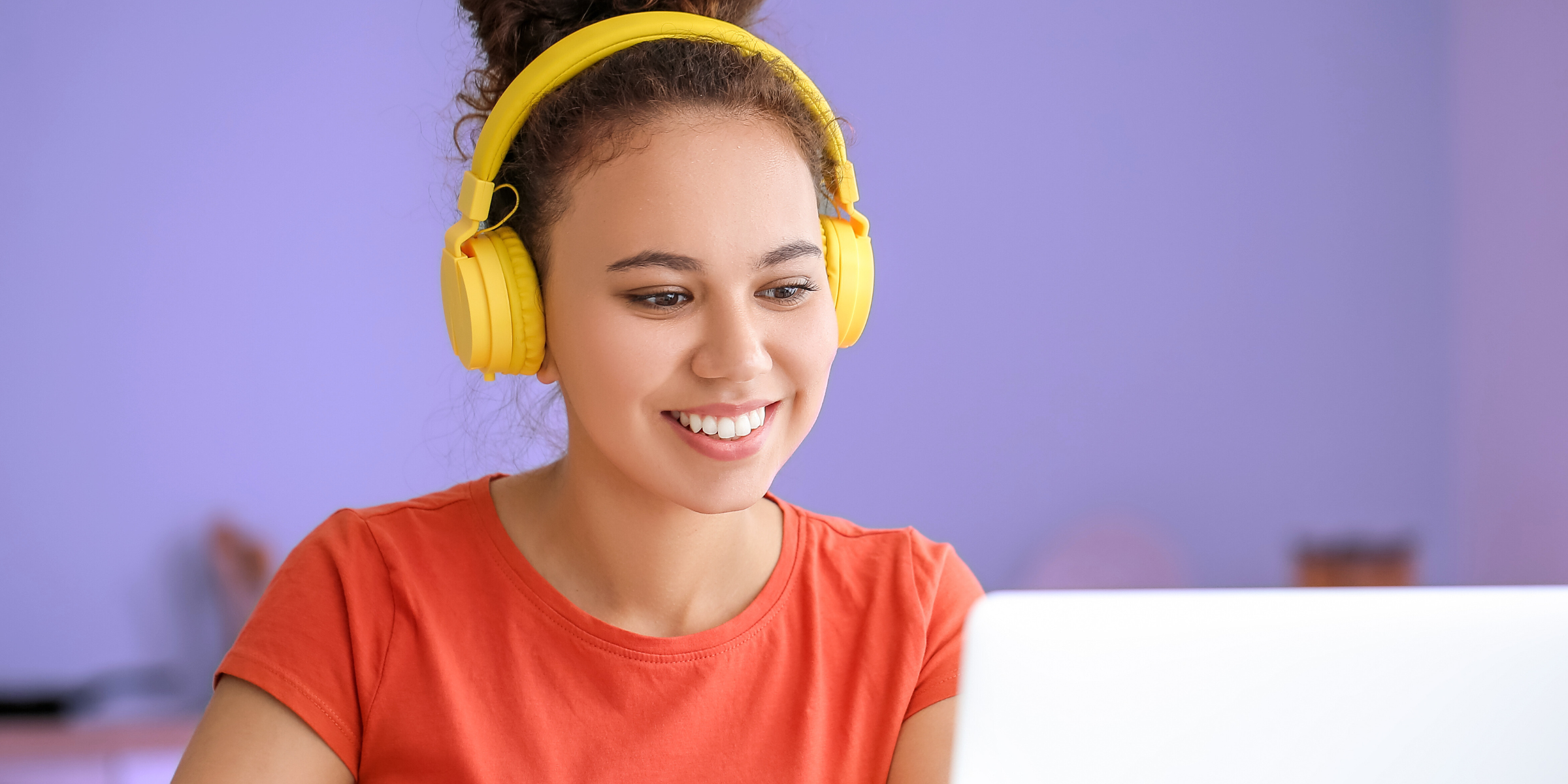 woman wearing yellow headphones taking online course on cannabis