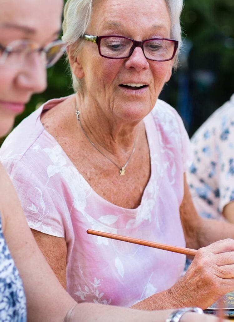 older women painting and socializing outdoors